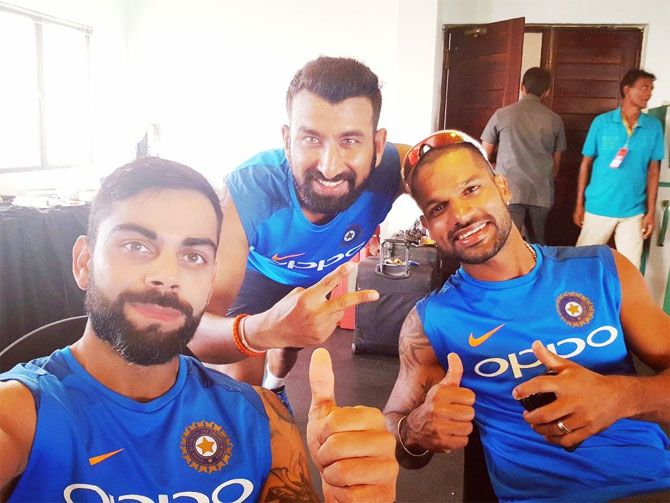 India captain Virat Kohli celebrates the Galle Test win with teammates Cheteshwar Pujara and Shikhar Dhawan in the dressing room