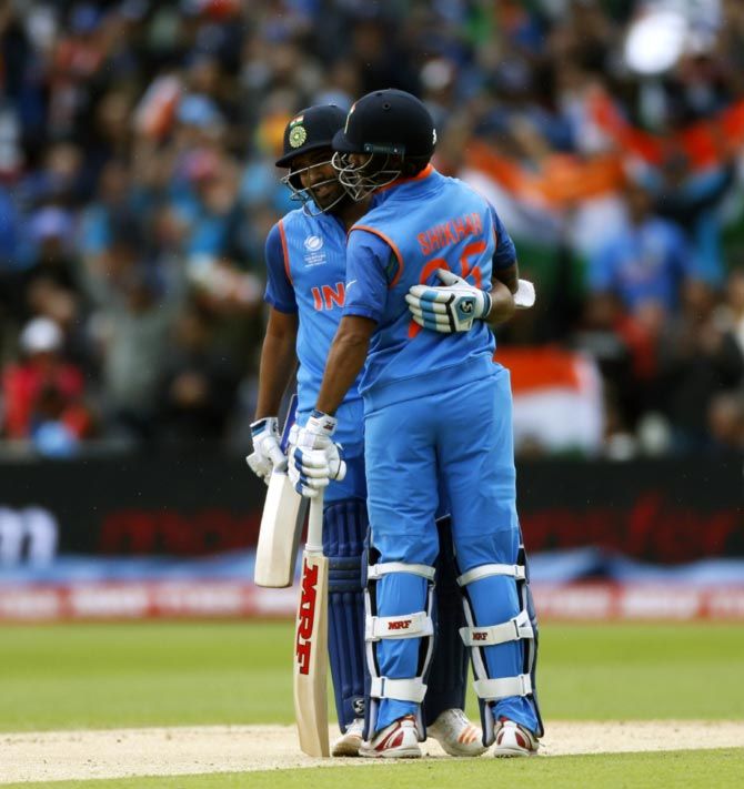 Rohit Sharma, left, is congratulated by Shikhar Dhawan after completing his half-century