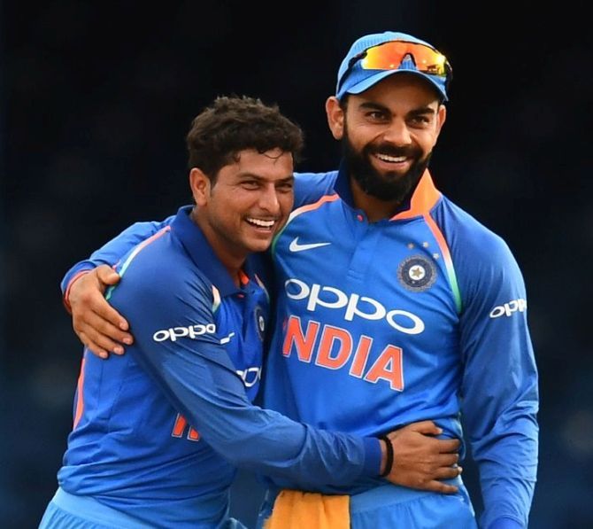 Kuldeep Yadav, left, celebrates a wicket with captain Virat Kohli