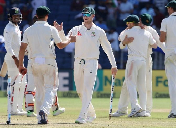  Australian players celebrate after winning the first Test match in Pune on March 1