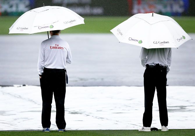 Umpires Rod Tucker and Bruce Oxenford inspect the pitch after a rain stoppage during Day 1 of the Test match between New Zealand and South Africa at Seddon Park in Hamilton, New Zealand, on Saturday