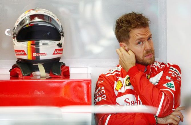 Ferrari driver Sebastian Vettel of Germany sits in team garage