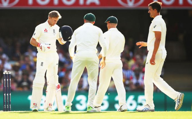 Australia players check on England captain Joe Root after he was struck on the helmet by a deivery from Mitchell Starc (right) during Day 3 of the first Ashes Test at The Gabba in Brisbane