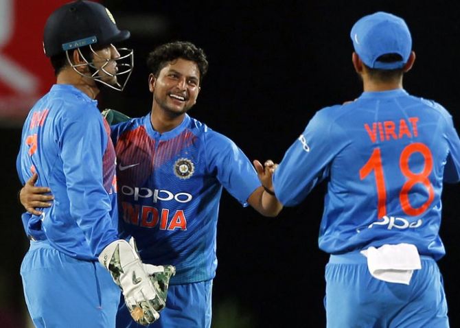 Kuldeep Yadav, centre, celebrates with Virat Kohli, right, and Mahendra Singh Dhoni after taking the wicket of Aaron Finch in the 1st T20 on Sunday
