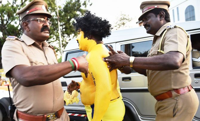 Policemen take away a fan of CSK Skipper MS Dhoni before the IPL match between Chennai Super Kings and Kolkata Knight Riders at MAC Stadium in Chennai on Tuesday