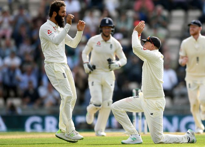 Moeen Ali, left, celebrates with team-mates after taking the wicket of Hardik Pandya