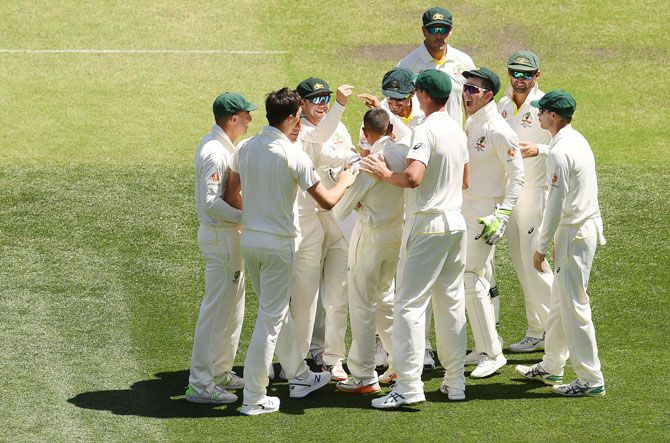 Australia's Usman Khawaja is congratulated by teammates after taking a blinder of a catch to dismiss India's Virat Kohli on Thursday