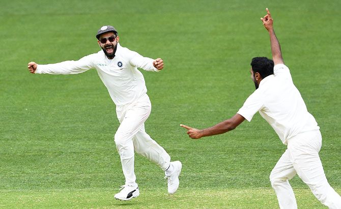 India's captain Virat Kohli (left) and his teammate Ravichandran Ashwin celebrate after India defeated Australia on Day 5 of the first Test at the Adelaide Oval in Adelaide on Monday