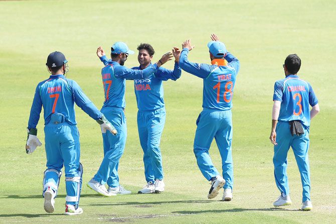 Kuldeep Yadav is congratulated by teammates after taking a wicket 