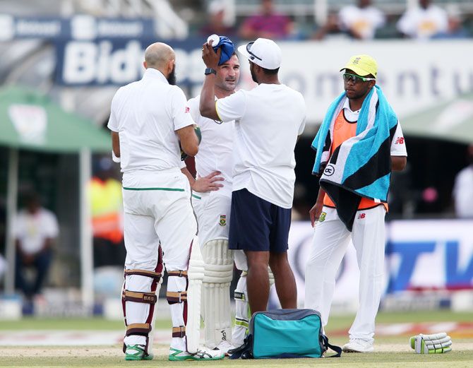 South Africa's Dean Elgar receives treatment from the team physio after copping one on the helmet off a Bumrah delivery