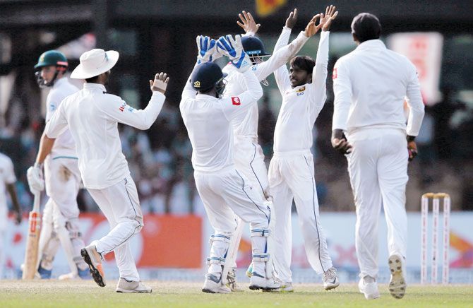 Sri Lanka's Akila Dananjaya (centre) celebrates with his teammates after taking the wicket of South Africa's Keshav Maharaj