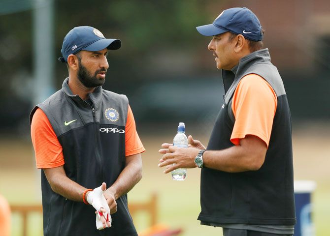 India head coach Ravi Shastri speaks with Cheteshwar Pujara during a training session