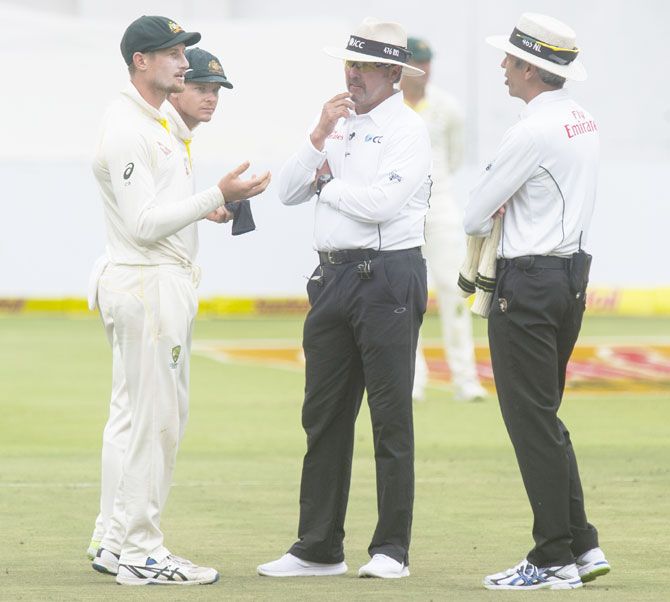 Umpires Nigel Llong and Richard Illingworth confront Australia's Cameron Bancroft on Day 3 of the third Sunfoil Test match against South Africa at PPC Newlands in Cape Town on March 24