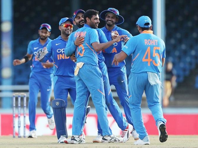 India pacer Bhuvneshwar Kumar is congratulated by skipper Virat Kohli and teammates after dismissing Roston Chase 