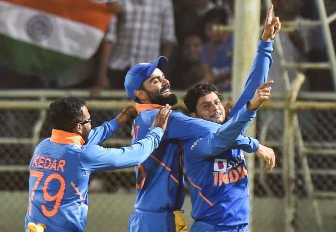 India's Kuldeep Yadav celebrates with skipper Virat Kohli and teammate Kedar Jadhav after completing his hat-trick during the 2nd ODI cricket against West Indies at ACA-VDCA Cricket Stadium in Visakhapatnam on Wednesday