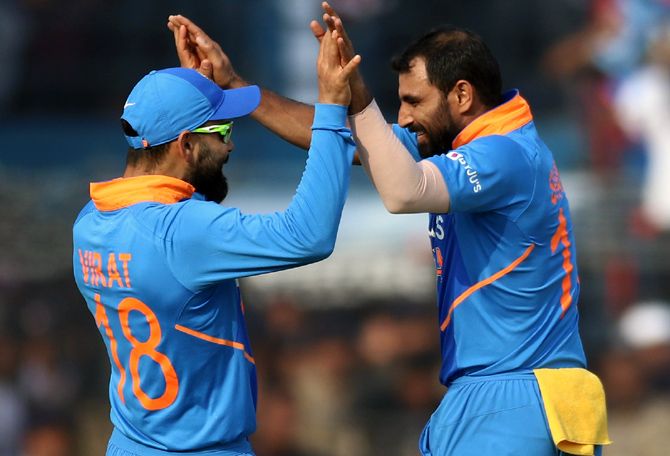 Mohammed Shami celebrates with captain Virat Kohli after picking the wicket of Shai Hope