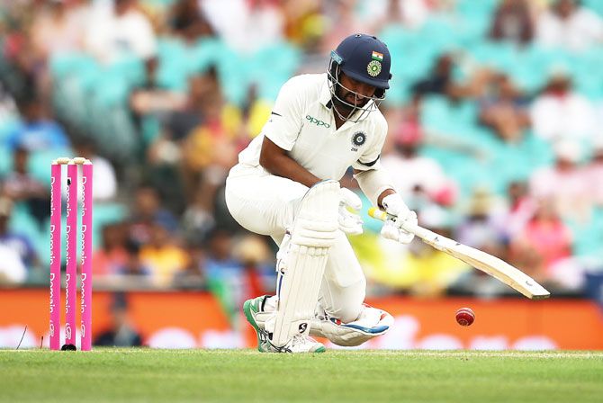 Cheteshwar Pujara is struck on the shoulder off a short ball from Mitchell Starc