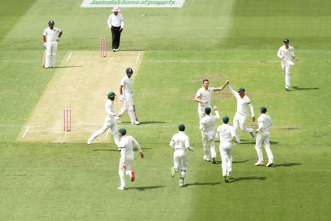 Josh Hazlewood celebrates with team-mates on dismissing KL Rahul