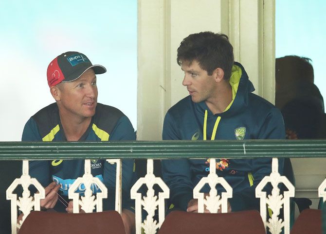Australian fielding coach Brad Haddin speaks to captain Tim Paine during the rain delay