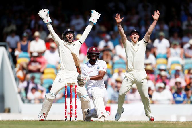 England's Ben Foakes and Ben Stokes celebrate the wicket of West Indies' John Campbell