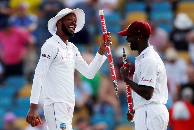 West Indies' Roston Chase celebrates with a teammate after winning the first Test against England on Saturday 