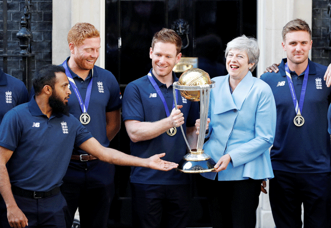 England's Eoin Morgan and Britain's Prime Minister Theresa May lift the trophy as they pose with the team outside number 10