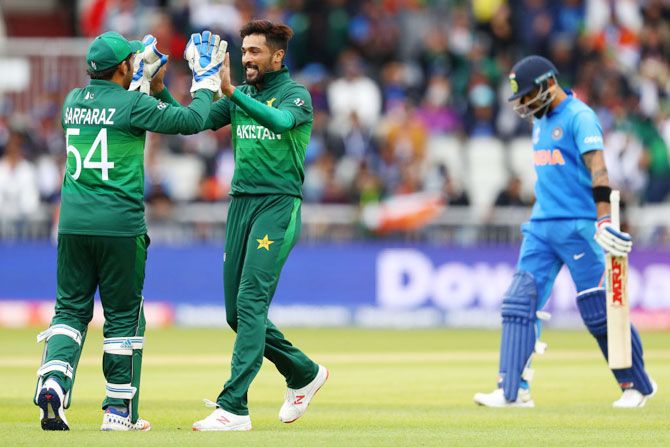 Pakistan's Mohammad Amir celebrates with Sarfaraz Ahmed after taking the wicket of India captain Virat Kohli during their match during the ICC Cricket World Cup at Old Trafford Manchester on Sunday