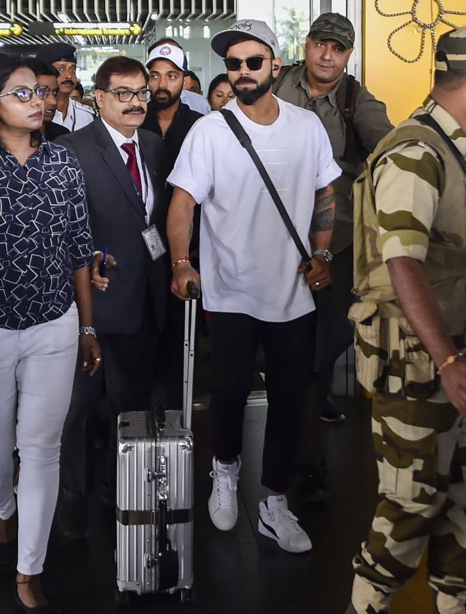 India captain Virat Kohli and Ajinjya Rahane (background) arrive at the Netaji Subhash Chandra Bose International Airport in Kolkata on Tuesday, ahead of India's first-ever Day/Night Test against Bangladesh