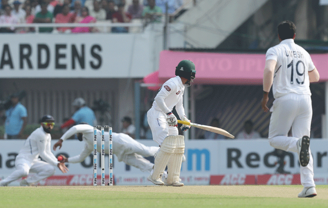 India's Rohit Sharma dives across to take a catch and dismiss Bangladesh captain Mominul Haque 