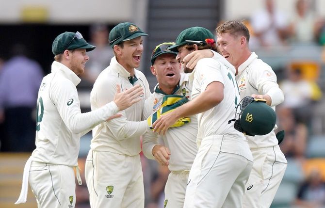 Tim Paine, Steve Smith, Joe Burns, David Warner and Marnus Labuschagne celebrate victory after Australia beat Pakistan on Day 4 of the first Test, at The Gabba in Brisbane, on Sunday.