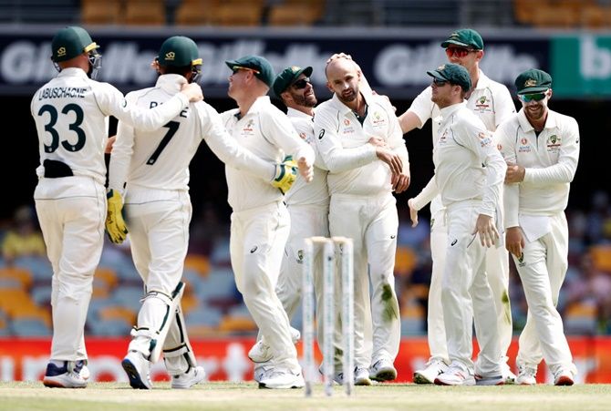 Nathan Lyon and wicketkeeper Tim Paine are congratulated by their Australia teammates after the dismissal of Pakistan's Babar Azam