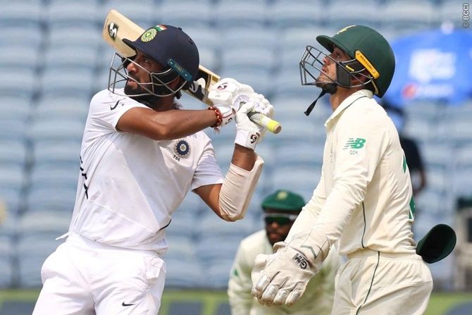 South Africa wicketkeeper Quinton de Kock watches as Cheteshwar Pujara hits a six off Senuran Muthusamy, the first of the match. 