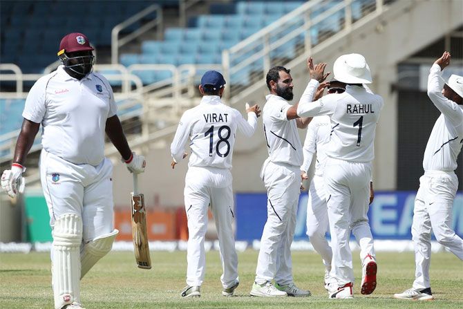 India's Mohammed Shami celebrates with teammates after taking the wicket of West Indies' Rahkeem Cornwall, his 150th Test victim