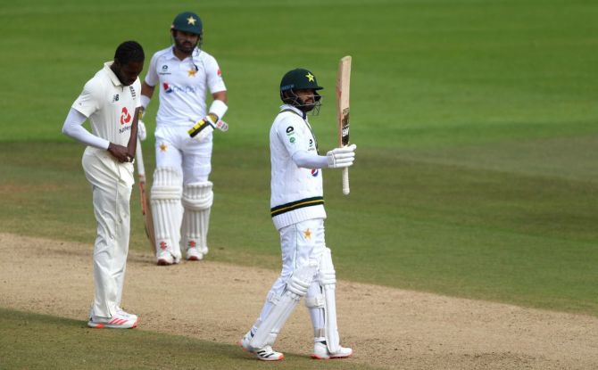 Azhar Ali acknowledges members in the dressing room on completing his half-century