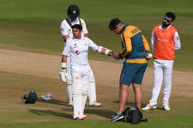 Abid Ali receives treatment from the physio after being struck on the hand