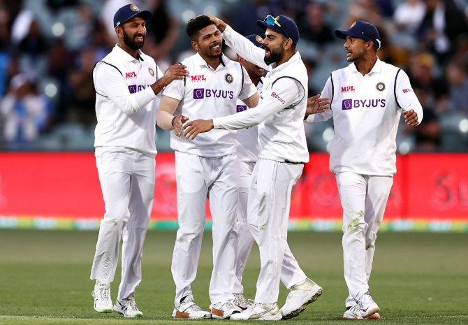 India's players celebrate after Umesh Yadav takes the wicket of Pat Cummins