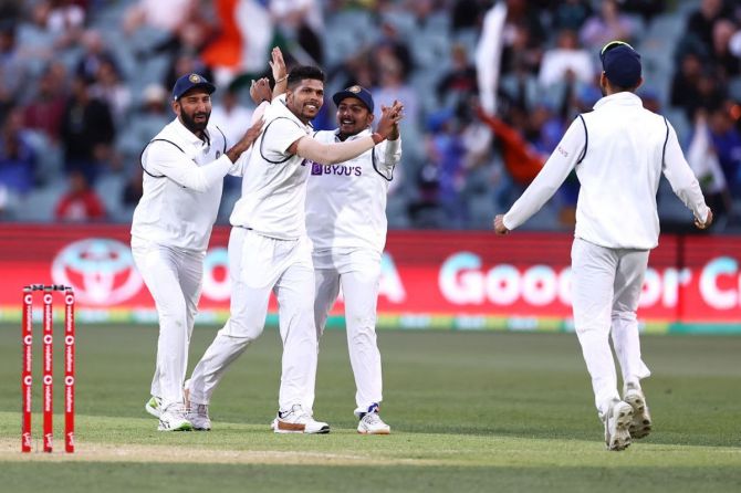 Umesh Yadav celebrates with his teammates after taking the wicket of Marnus Labuschagne