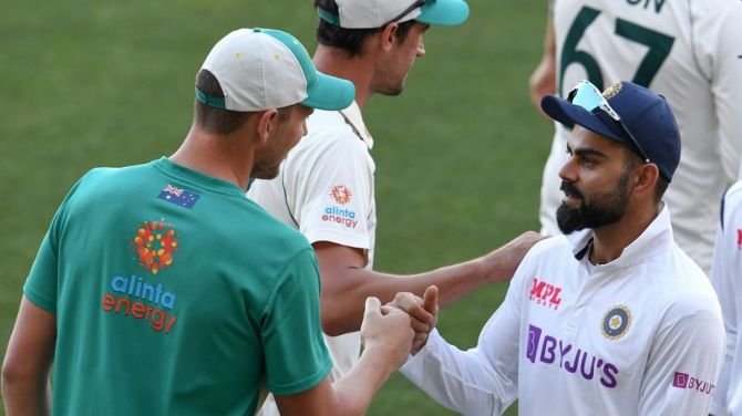 Josh Hazlewood is congratulated by Virat Kohli after the first Test on Saturday