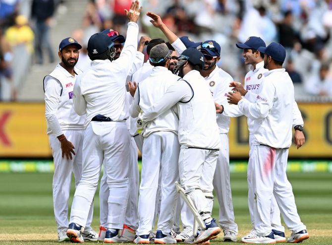 Ravindra Jadeja is congratulated by teammates after getting the wicket of Tim Paine