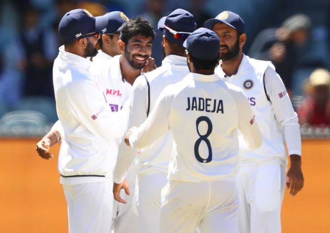 Pacer Jasprit Bumrah is congratulated by his India teammates after dismissing Australia's Pat Cummins on Day 4 of the second Test, at the Melbourne Cricket Ground, on Tuesday. 