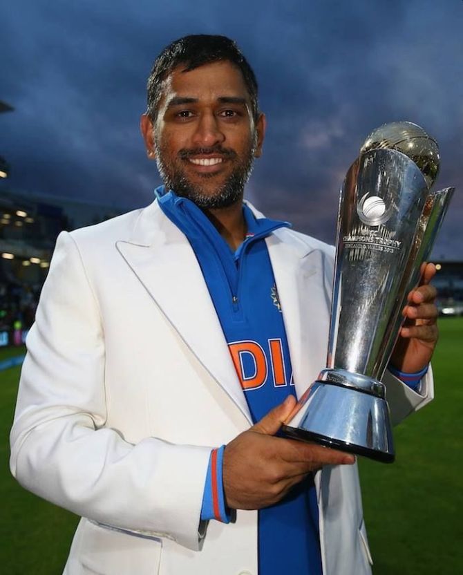 Mahendra Singh Dhoni poses with the ICC Champions Trophy in 2013