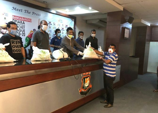 Bangladesh Cricket Board officials hand out grocery bags to Cricket Committee of Dhaka Metropolis (CCDM) to be distributed among the poor.