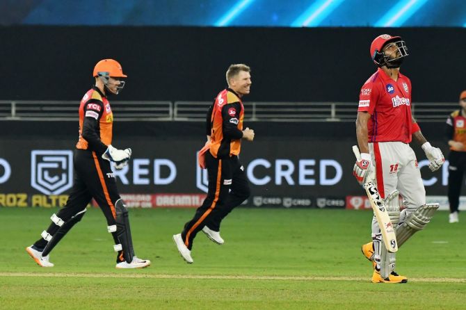Kings XI Punjab skipper K L Rahul walks back as Sunrisers Hyderabad captain David Warner and wicketkeeper Jonny Bairstow celebrate his dismissal.