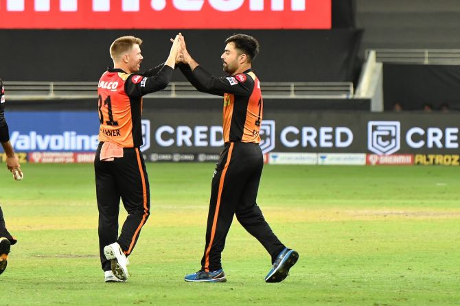 SunRisers Hyderabad captain David Warner celebrates with Rashid Khan after the thumping victory over Delhi Capitals in the IPL match in Dubai on Tuesday.