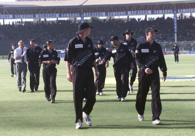 New Zealand's players leave the ground after spectators throw empty bottles on one of their players during their first One-Day International in Karachi on April 21, 2002.
