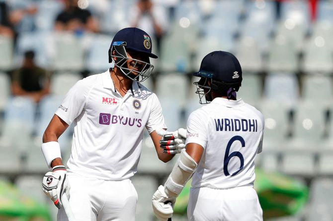 Axar Patel is congratulated by Wridhhiman Saha after hitting one of his four sixes during his 41 off 26 balls in India's second innings against New Zealand on Day 3 of the second Test, in Mumbai, on Sunday.
