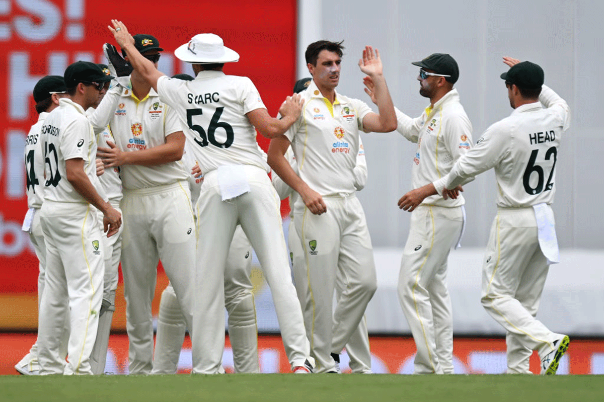 Australia's Pat Cummins celebrates with his team after dismissing England's Rory Burns.