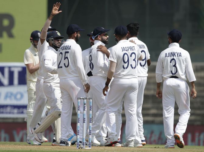 India's players celebrate the wicket of Rory Burns.