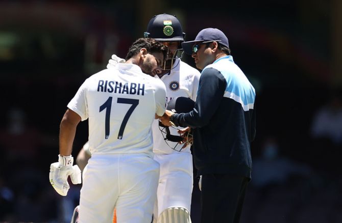 Rishabh Pant is assessed after being stuck on the helmet.
