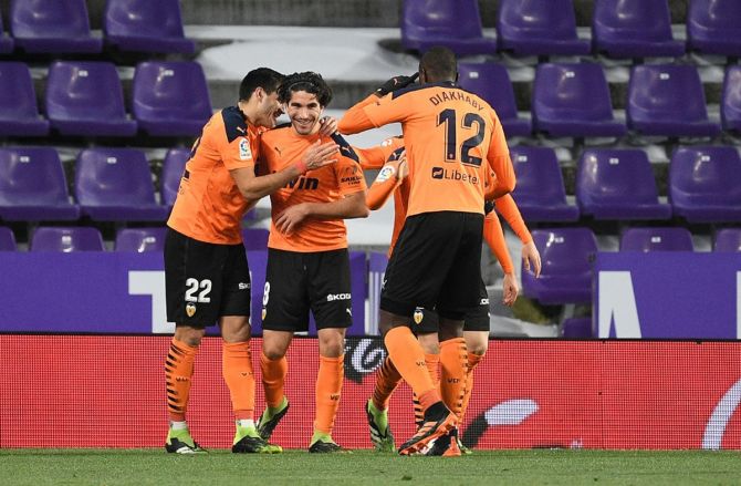Carlos Soler  is congratulated by teammates Maximiliano Gomez and Mouctar Diakhaby after scoring for Valencia